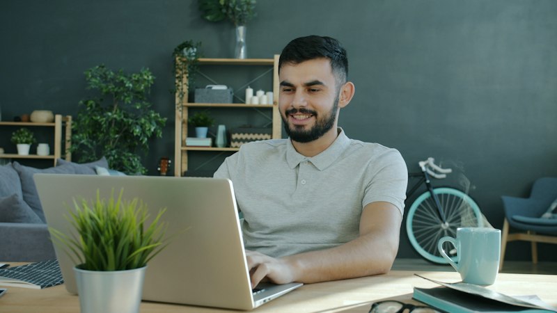 Business owner smiling at his laptop