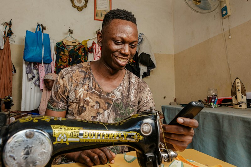 Smiling tailor at his sewing machine